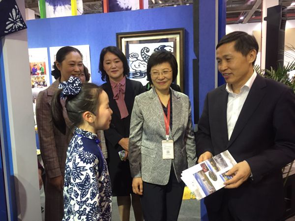 图为教育部副部长钟登华（右一）在实验小学和实验中学的蓝印花布工作坊参观，并听取小学生的介绍。徐艳梅摄_副本.jpg